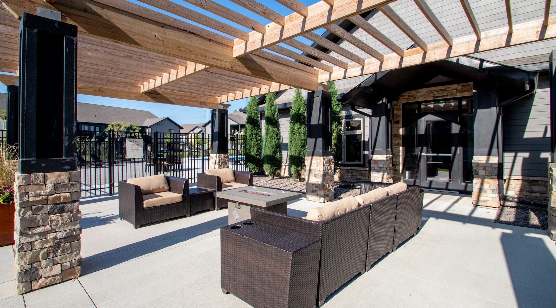 an outdoor lounge area with a firepit and chairs